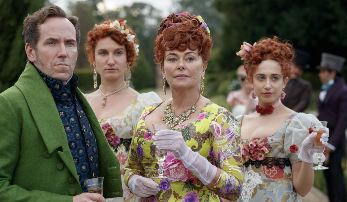 Bridgerton albero genealogico. Famiglia Featherington. Da sinistra: Lord Featherington (Ben Miller), Prudence (Bessie Carter), Lady Portia (Polly Walker), e Philippa (Harriet Cains) in una scena di Bridgerton. Credits: Liam Daniel/Netflix.