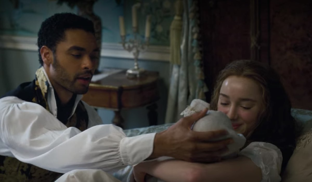 Simon (Regé-Jean Page) e Daphne (Phoebe Dynevor) accogliono il loro primogenito. Credits: Netflix.