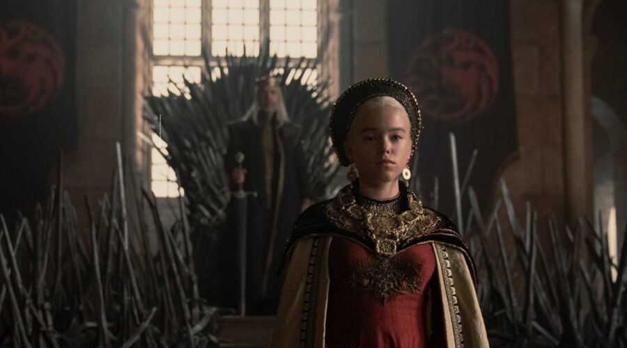 In primo piano Milly Alcock (Principessa Rhaenyra da giovane) di spalle al trono di spade, sullo sfondo Paddy Considine (Re Viserys I) in una scena di “House of the Dragon”. Courtesy of HBO