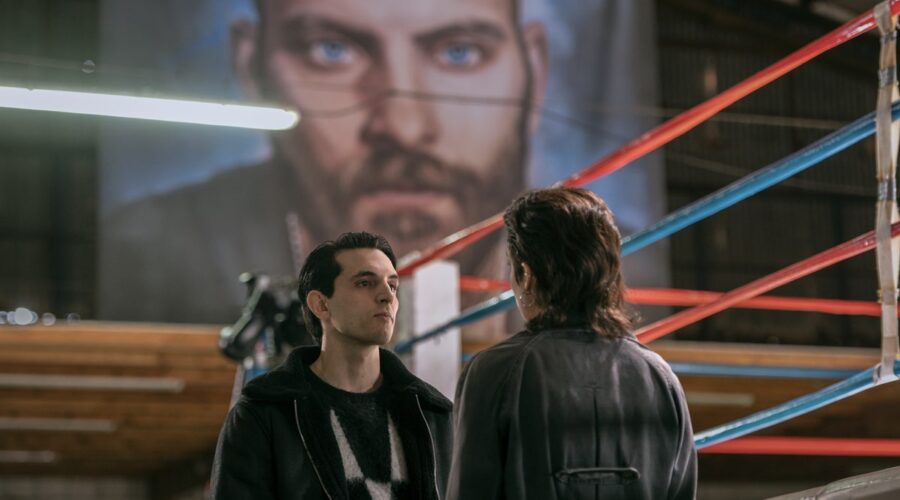 Il telo con dipinto il volto di Aureliano campeggia sulle teste di Alberto (Gacomo Ferrara) e Nadia (Federica Sabatini) in una scena di “Suburræterna”. Credits: Emanuela Scarpa/Netflix © 2023.