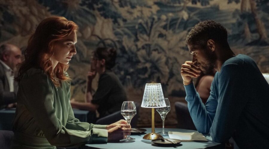 Da sinistra: Eleanor Tomlinson e Alfred Enoch in una scena de “La Coppia Della Porta Accanto”. Credits: Channel 4.