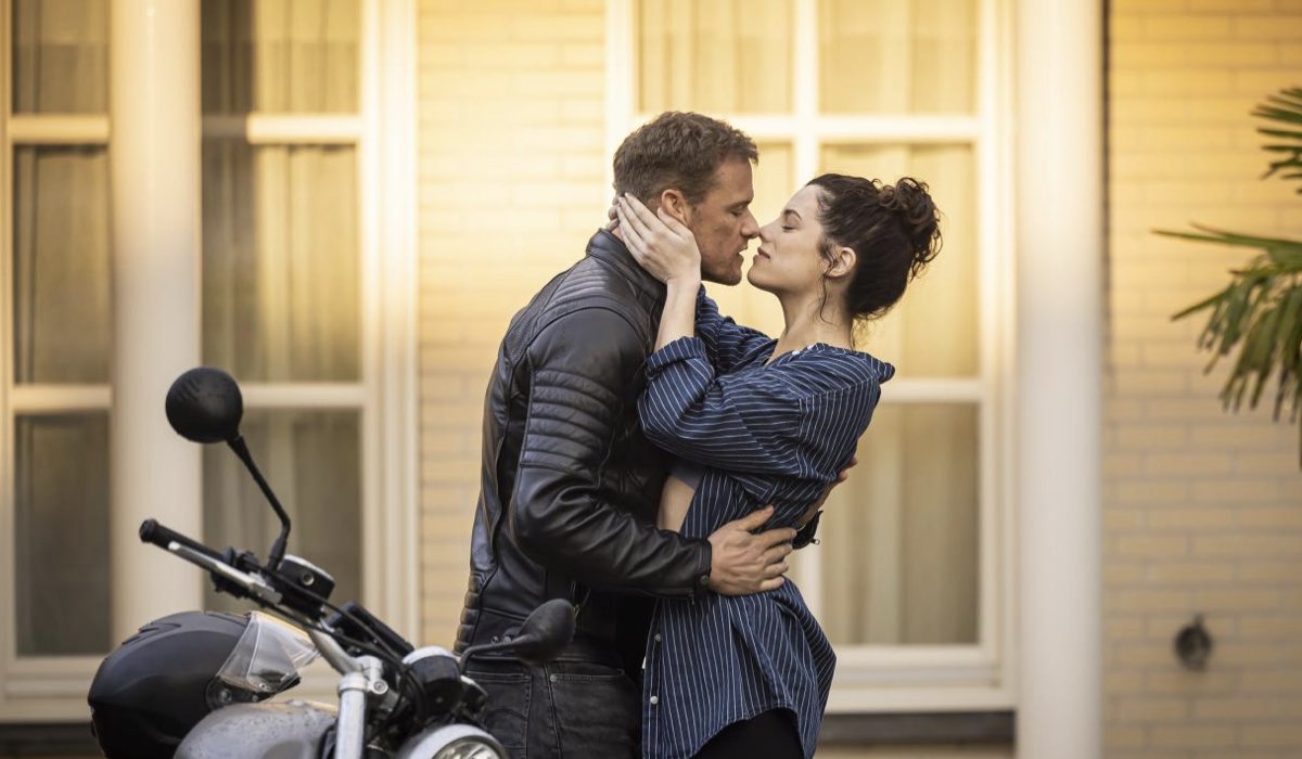 Da sinistra: Danny (Sam Heughan) e Becka (Jessica De Gouw) in una scena de “La Coppia Della Porta Accanto”. Credits: Channel 4.